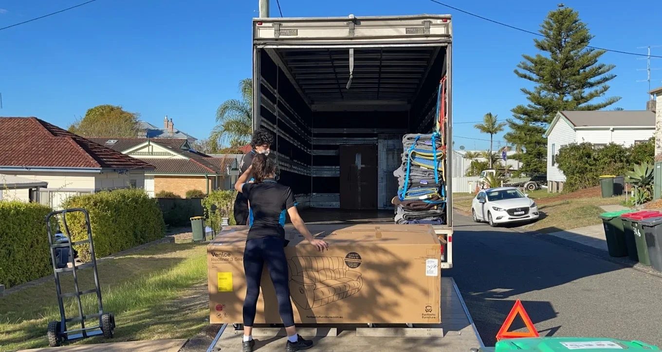 Removalist moving a large crate to the back of the truck