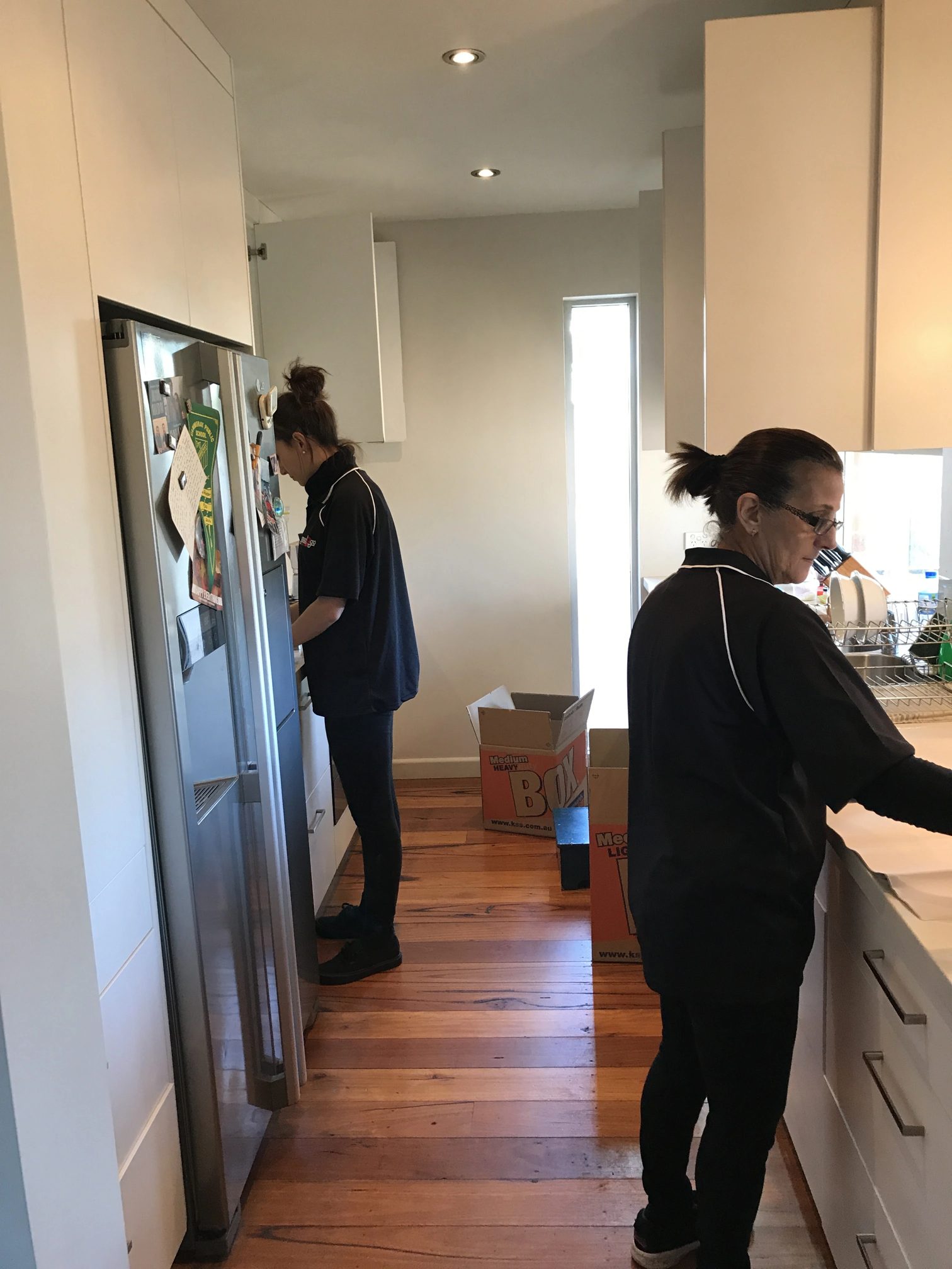 Two removalists packing a kitchen in a Central Coast home